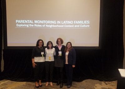 Lab stands in front of their finished presentation on Parental Monitoring in latino families